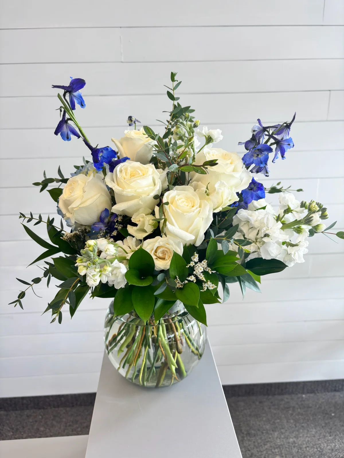 White and blue sympathy flower arrangement in a glass vase by a Hilliard Ohio florist